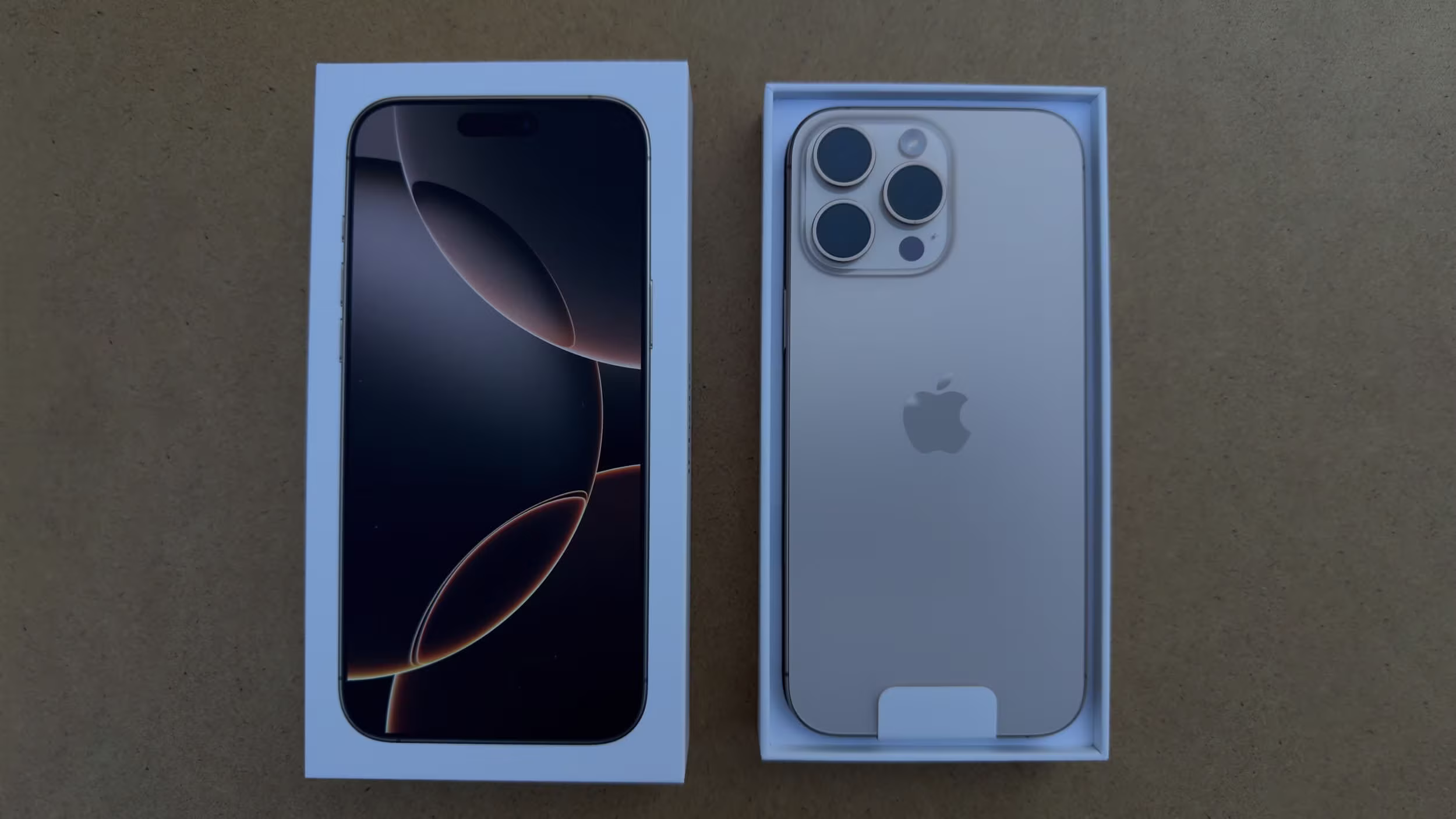 iPhone 16 shown inside its box with both front and back sides visible