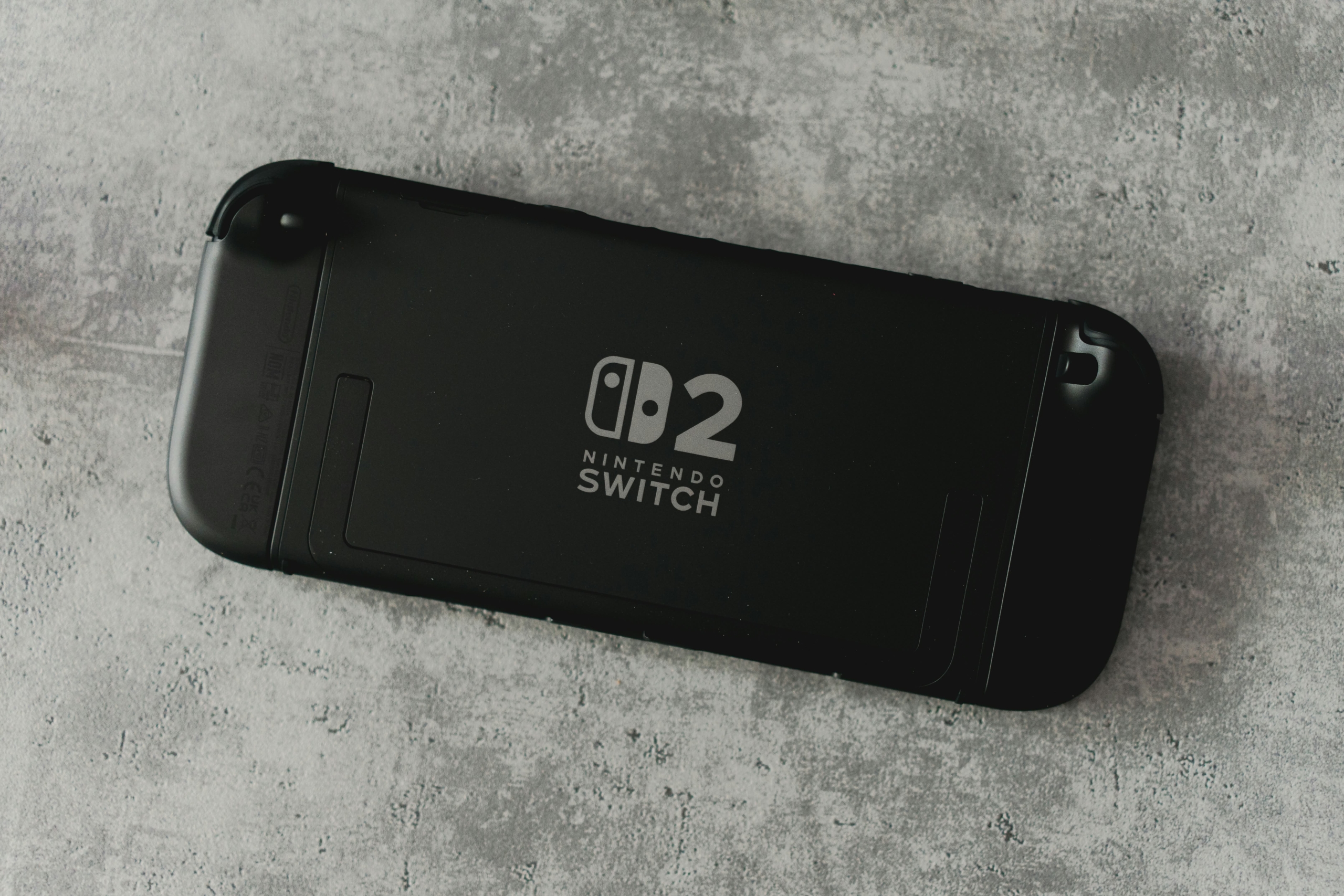 Black Nintendo Switch console with logo on a textured surface.