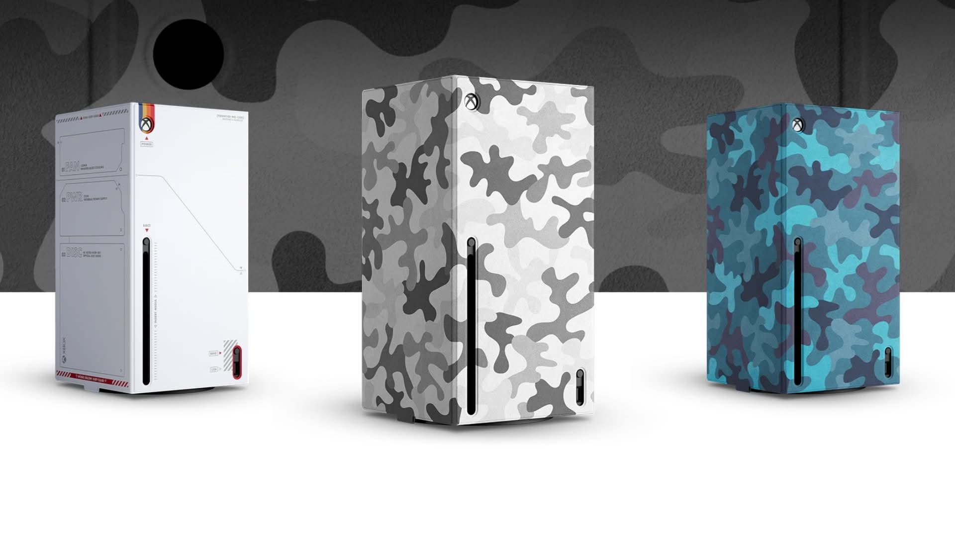 Three Xbox Series X consoles displayed with different console wraps: a white design and two camouflage patterns (grey and blue)